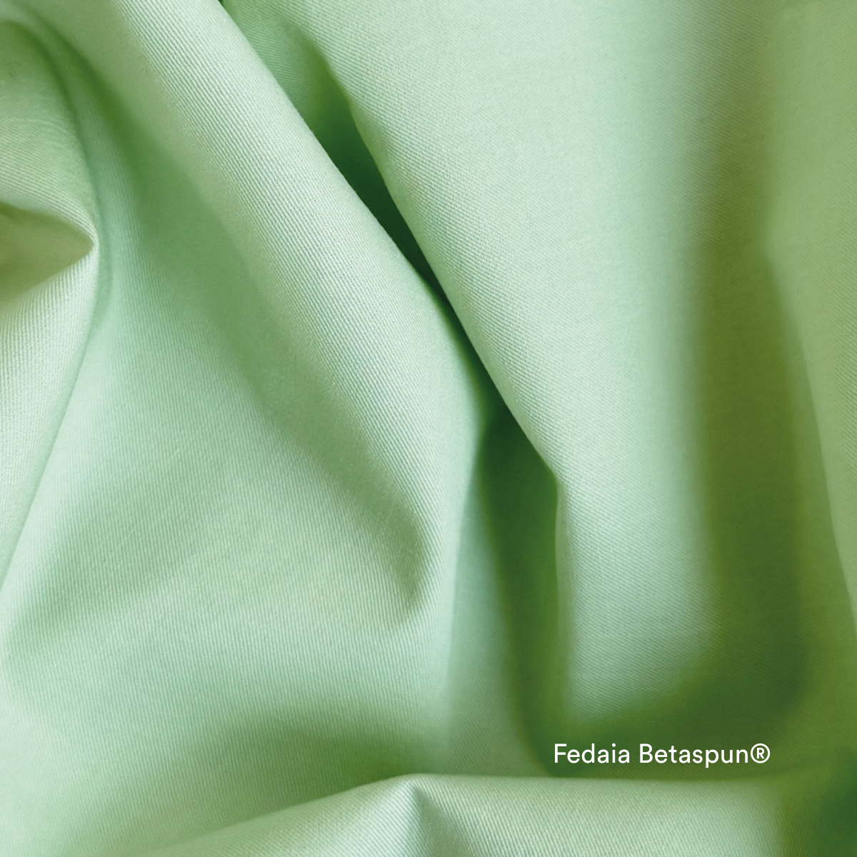Light green fabric with subtle folds and creases, creating a soft, textured appearance. The words Fedaia Betaspun® are printed in white in the lower right corner.