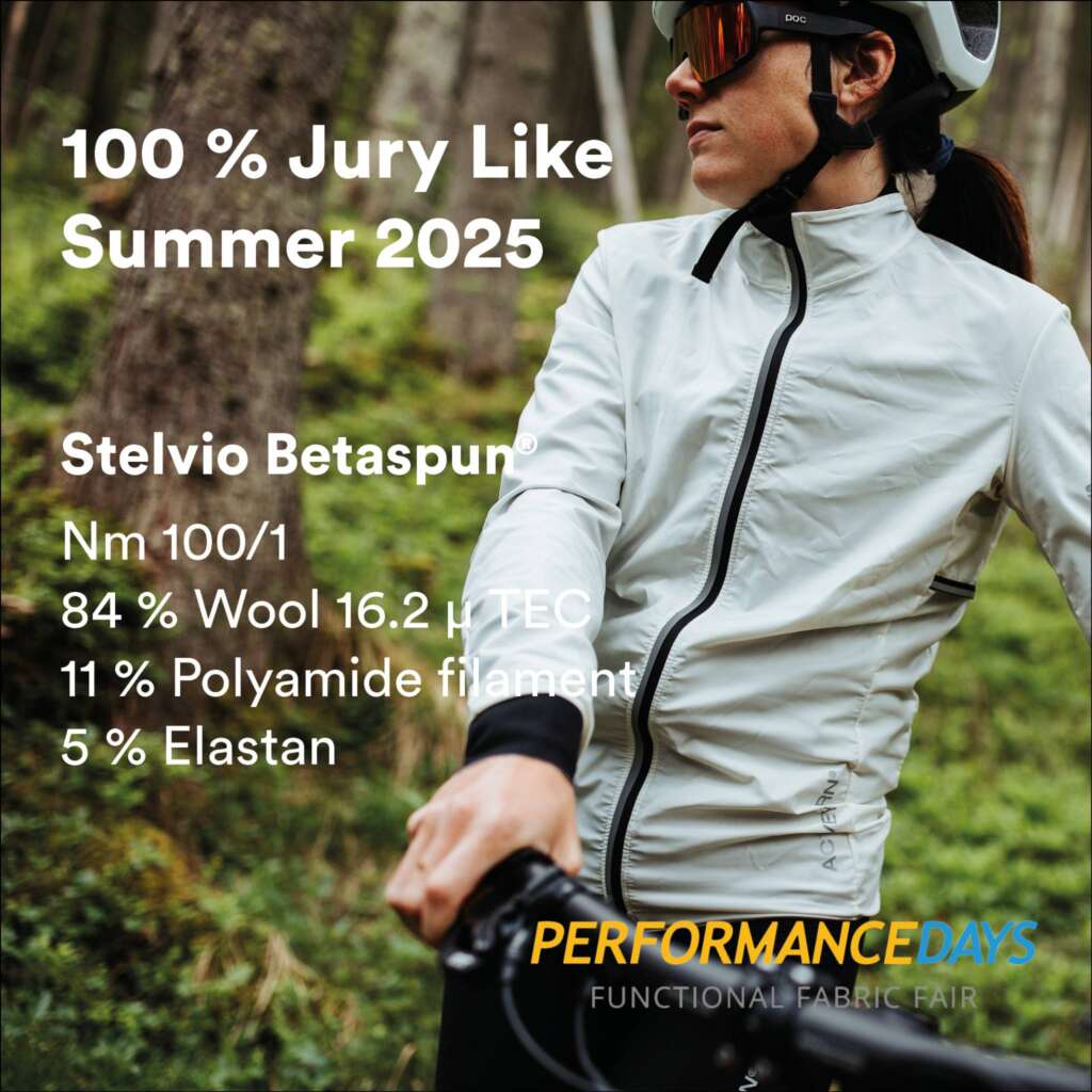 A cyclist wearing a light jacket and helmet rides through a forest. Text highlights 100% Jury Like Summer 2025 and fabric details: Stelvio Betaspun, wool blend, and mentions Performance Days fabric fair.