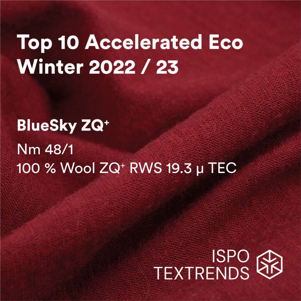 Close-up of deep red wool fabric with overlaid text showcasing BlueSky ZQ+, a top eco textile for Winter 2022/23, made of 100% Wool, with ISPO Textrends and quality details.